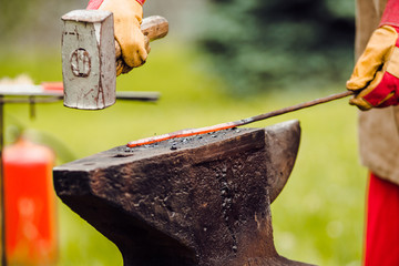 A smith forging a horse shoe on an anvil
