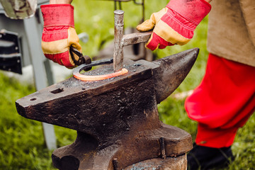 A smith forging a horse shoe on an anvil