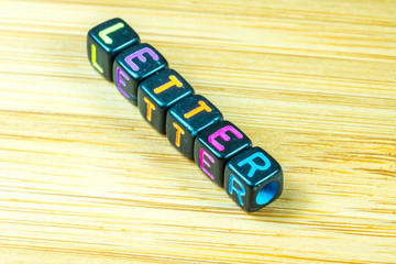 Colorful letter cube with bamboo texture surface. Educational co