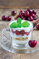 Cherry, muesli and yogurt dessert in glass, verrine, vertical