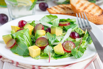 Vegetarian salad with avocado, grape, rucola, onion, vinegar dressing
