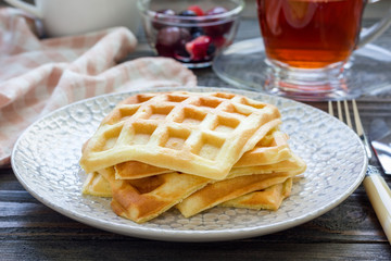 Homemade belgian waffles for breakfast, served with fruit and tea