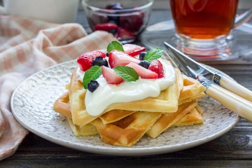 Homemade belgian waffles with yogurt, strawberry and blueberry, breakfast time