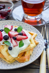 Homemade belgian waffles with yogurt, strawberry and blueberry, breakfast time