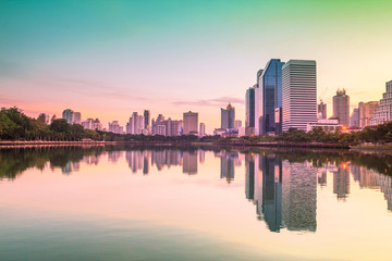 Fototapeta premium Bangkok city sunrise reflection river of sun. Panoramic view light blue background of glass high rise building skyscraper commercial of future. Business concept of success industry tech architecture
