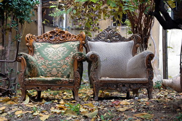 Two antique chairs on the street in autumn day 