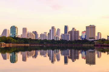 Fototapeta na wymiar Bangkok city sunrise reflection river of sun. Panoramic view light blue background of glass high rise building skyscraper commercial of future. Business concept of success industry tech architecture
