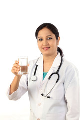 Happy young female doctor with a glass of water