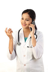 Young female doctor talking on mobile phone