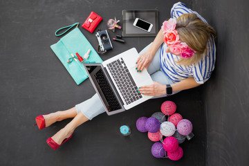 Modern woman sitting on the floor with computer in her lap