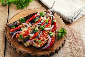 baked eggplant with cheese and tomatoes on a wooden surface