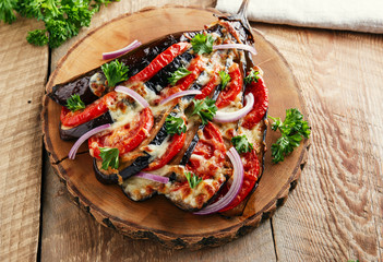 baked eggplant with cheese and tomatoes on a wooden surface