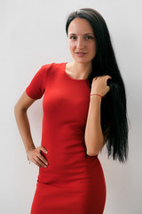 Elegant woman in red dress with long black hair smiling at camera