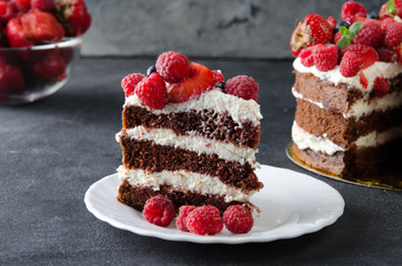 Naked cake with cream, decorated with raspberries, blackberries.