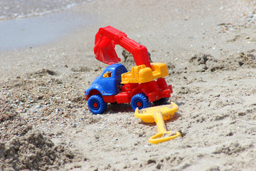 toy car-ekskovator and shovel on the sandy coast