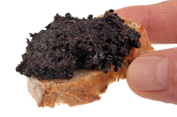 Tartine avec de la tapenade tenue an main