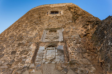 Heraldic shields on the tower of the medieval castle in Consuegra. Spain.