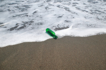 砂浜の緑の小瓶