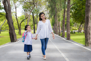 Asian mother and daughter student walking to school.Pupil studen