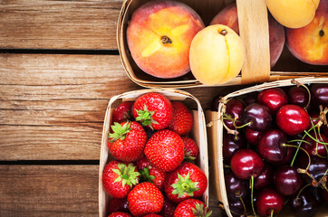 Naklejka na ściany i meble Fresh ripe summer berries and fruits in baskets