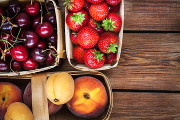 Fresh ripe summer berries and fruits in baskets