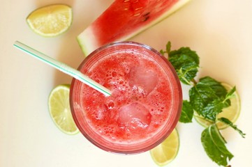 Healthy fresh smoothie drink from red watermelon, lime, mint and ice drift