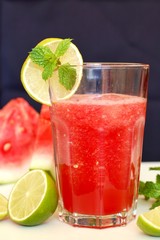 Healthy fresh smoothie drink from red watermelon, lime, mint and ice drift