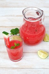 Healthy fresh smoothie drink from red watermelon, lime, mint and ice drift