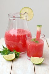 Healthy fresh smoothie drink from red watermelon, lime, mint and ice drift