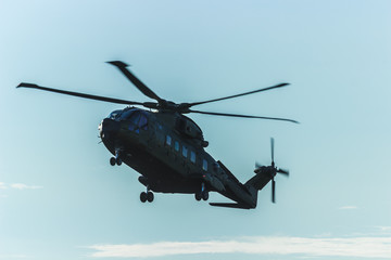 Naklejka na ściany i meble Military helicopter in the sky,close up of a military helicopter in flight