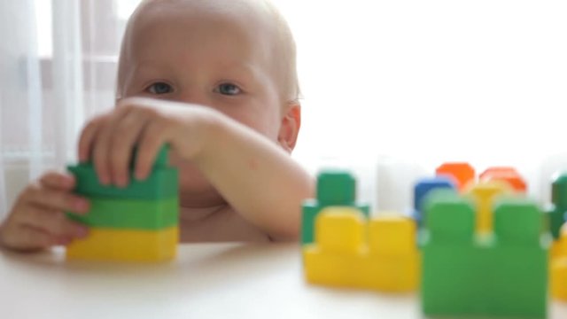 Little cute toddler playing with color blocks