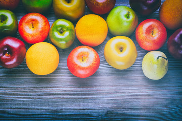 Ripe red green and yellow apples on wooden board background