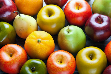 Ripe apples pears and oranges on wooden board background