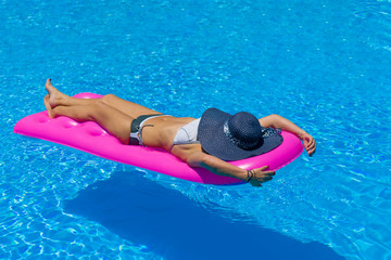 Beautiful young woman in bikini Relaxing in a pool