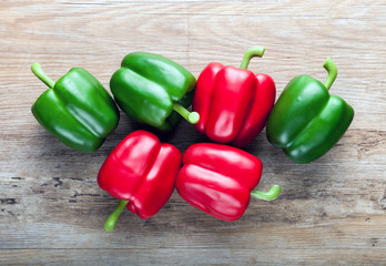 Fake red and green peppers on wooden board background