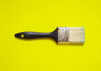 A decorators paint brush on a yellow background