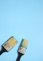 Decorators paint brushes on a blue background creating a page border