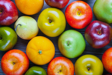 Ripe apples pears and oranges on wooden board background