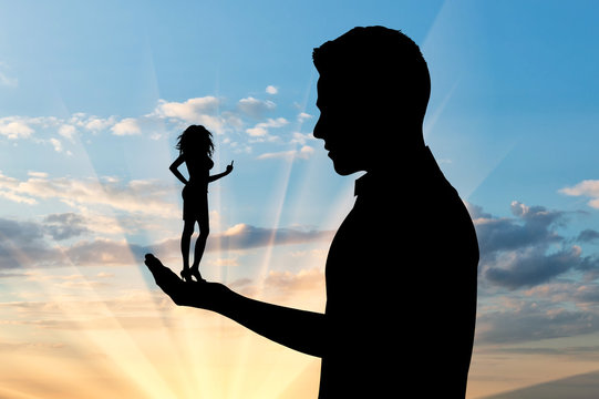 Silhouette of a small woman showing, fuck you, in the hand of man