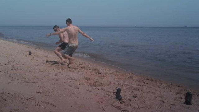 Two guys playing mini football on the beach at seaside