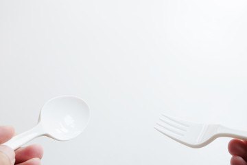 hand are holding white Spoon and fork on white background with path..