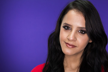 Woman looking into the camera on a purple background