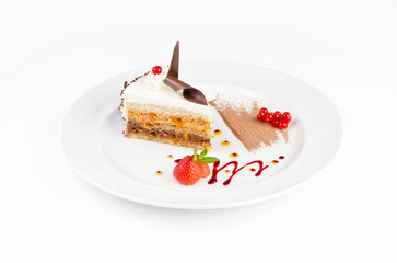 Beautiful cake in a plate with strawberries and red currants on a white background