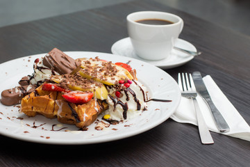 Belgian waffles with ice cream, chocolate and strawberries