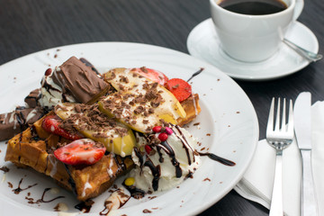Belgian waffles with ice cream, chocolate and strawberries
