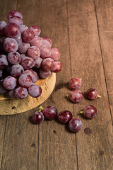 bunch or red grapes on a wood surface