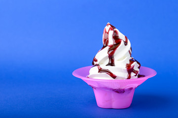 frozen yogurt with black cherry topping on blue background