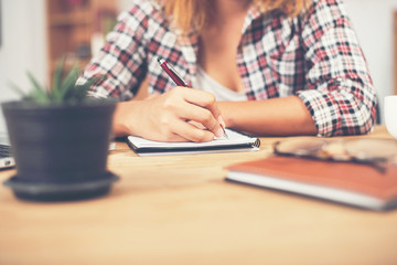 Young hipster woman writing and work in workplace.