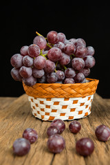 bunch or red grapes on a wood surface