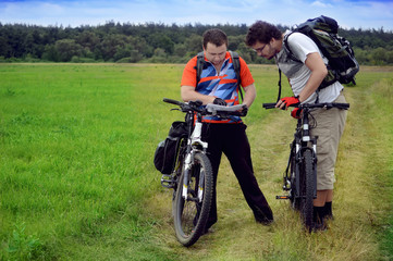 Fototapeta na wymiar two guys with bikes and tourist map
